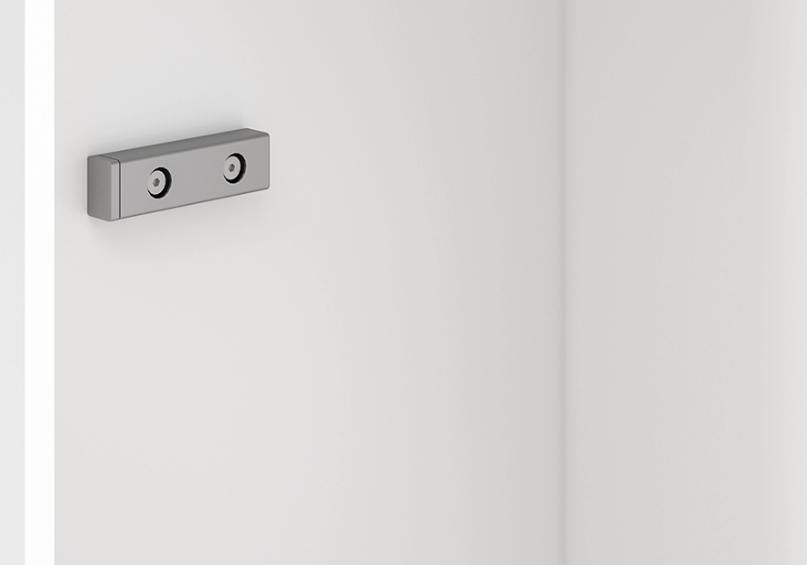 Detail van een metalen bevestigingsplaat op een witte kast, ideaal voor opklapbed systemen.